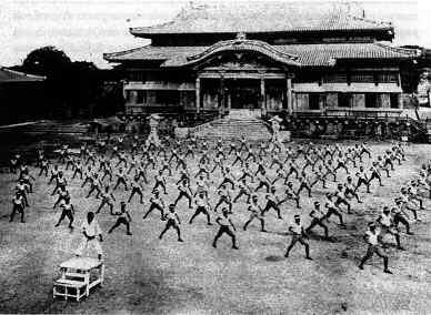 l'adozione di questo nuovo sistema divenne anche una formazione di massa o di gruppo. La pedagogia di Itosu si ispira ai metodi di formazione dei soldati che il Giappone stava importando dall'europa.