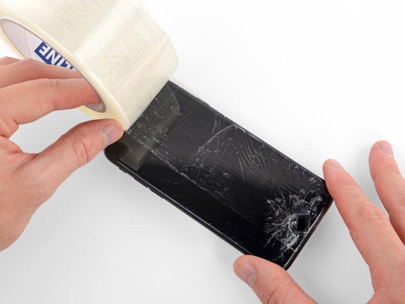 Stendi delle strisce sovrapposte di nastro adesivo da pacchi trasparente sul display dell'iphone fino a coprire l'intera superficie.