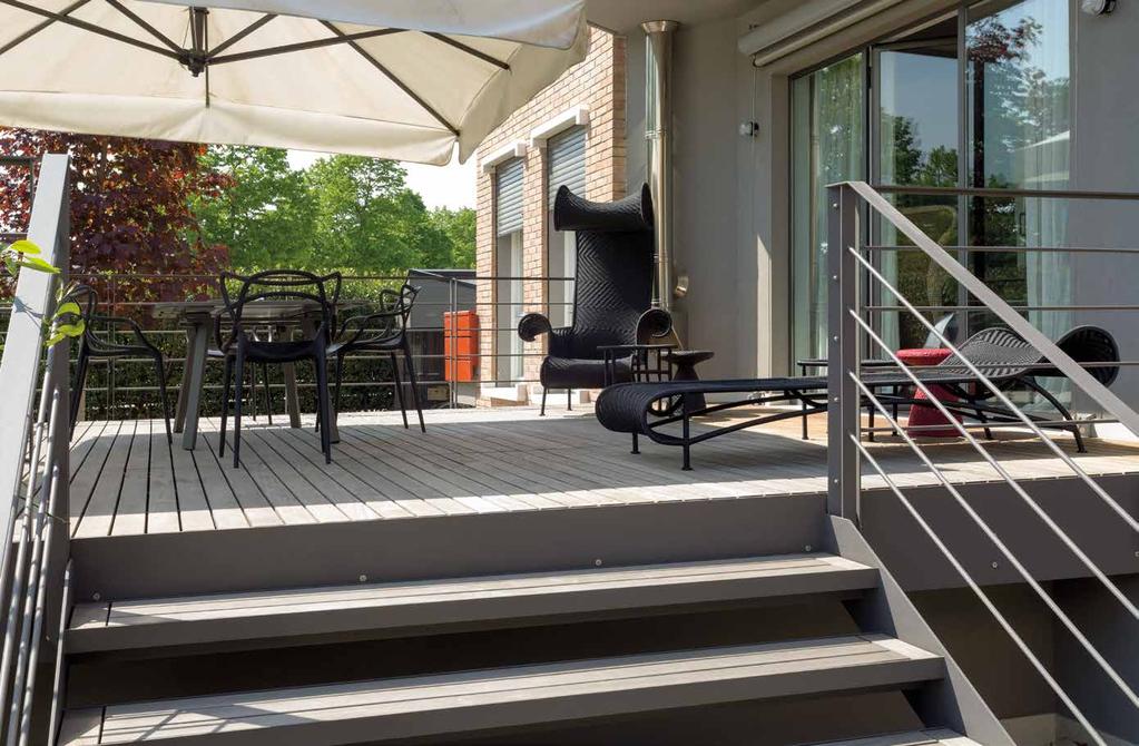 La soleggiata e abitabile terrazza ha un arredo da esterno di Moroso, sedie Kartell e ombrellone in acciaio Coro Italia (Armonia Interni).