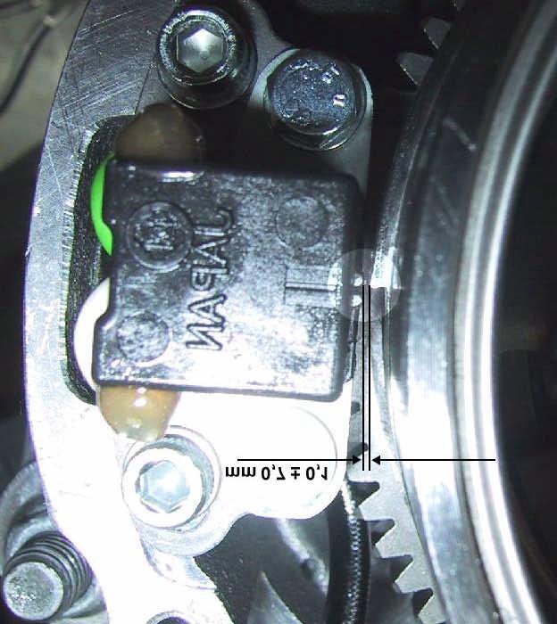 Picture 2 Position between flywheel and pick-up when piston is 0 before T.D.C. If necessary, move the pick-up to adjust. Check if the distance between pick-up and flywheel is correct (Picture 2).