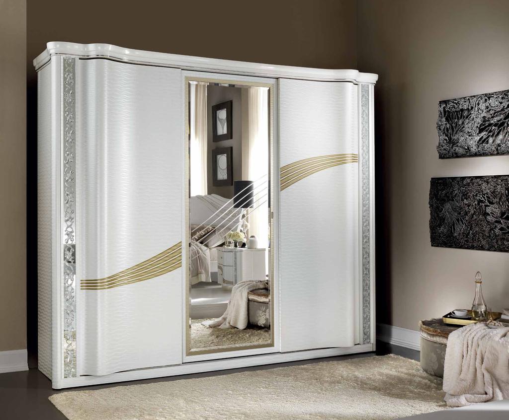 The large, sinuous sliding doors of the wardrobe give the bedroom a refined elegance.
