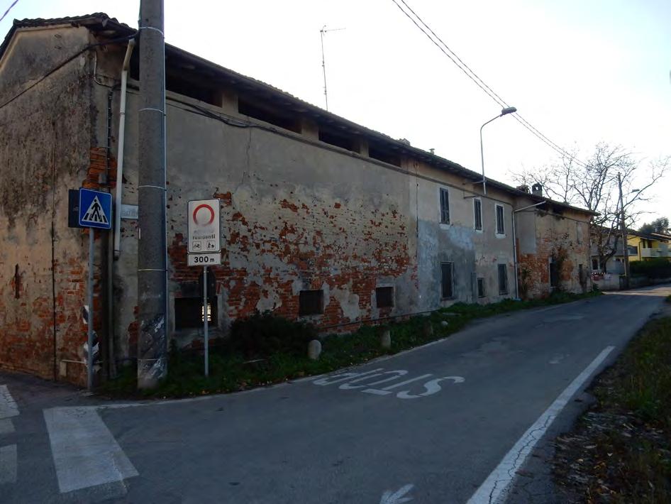 Muro continuo articolato su più livelli: da muro di recinzione diventa muro perimetrale delle abitazioni e della cascina senza discontinuità.