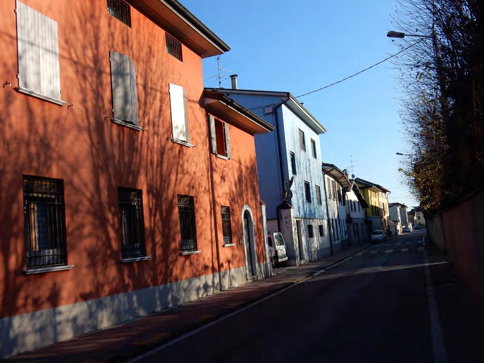 Muro continuo articolato su più livelli interrotto da cancelloni e portoni di ingresso.