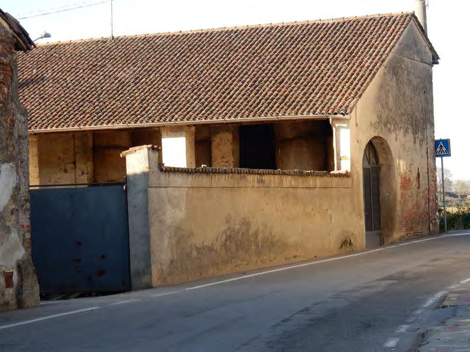 Muro continuo articolato su più livelli: da muro di recinzione diventa muro perimetrale del fienile interrotto dal portone di ingresso.