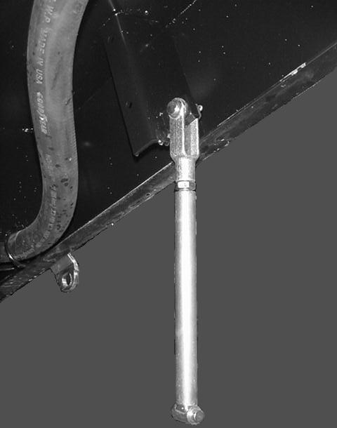 Togliete i due bulloni posteriori e i dadi flangiati dalla staffa del cilindro di sollevamento; conservate i dispositivi di fissaggio per utilizzarli in seguito.