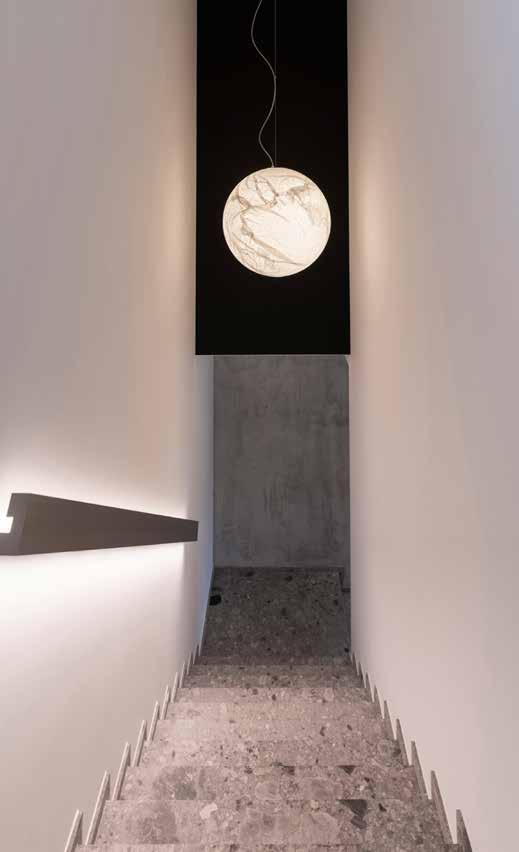Scala in ceppo di Gré e parete nera che fa da sfondo alla magica lampada Moon di Davide Groppi (Zenucchi Arredamento). ENGLISH TEXT.