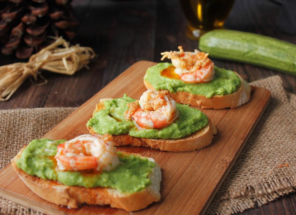 I crostini con gamberi e crema di zucchine sono un sfizioso antipasto perfetto per iniziare un pranzo o una cena a base di pesce.