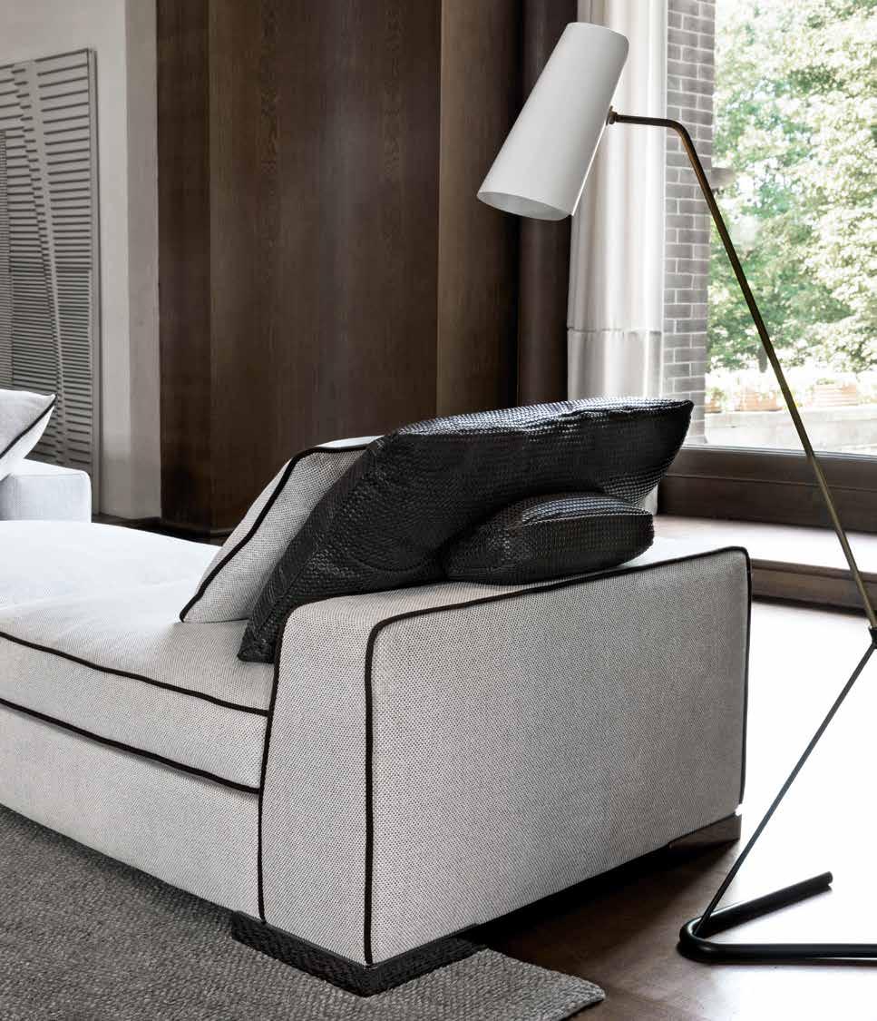 La morbida silhouette del divano Armand è sottolineata dalla confezione sartoriale dei profili che rifiniscono braccioli e cuscini, per i quali si può scegliere un ricercato profilo in gros grain
