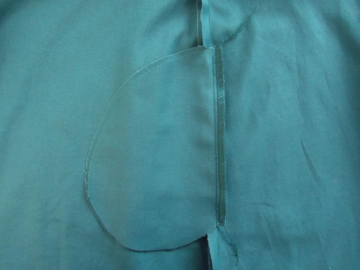 Taglia lo spacco, taglia la stoffa lasciando un margine di cucitura stretto, rivolta la paramontura e stira.
