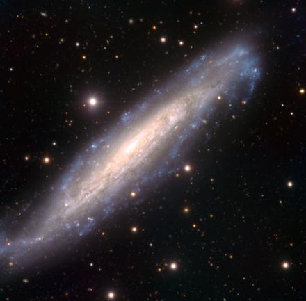 9,8, è una bella galassia a spirale barrata vista quasi frontalmente, con un evidente anello interno ed una barra ben delineata da cui dipartono due bracci ben definiti e fortemente avvolti, mentre