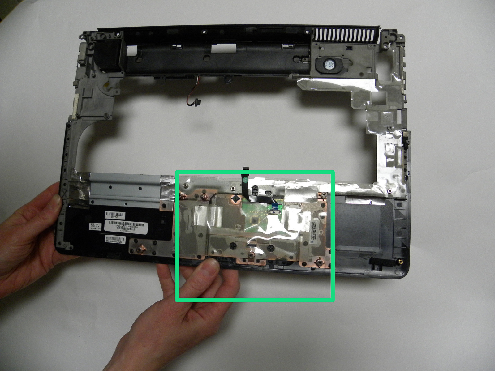 Passo 33 Ora che il coperchio superiore è stato rimosso, verificare la presenza di particelle di detriti o alimentari che possono essere intrappolati sotto zona pulsante del trackpad del coperchio