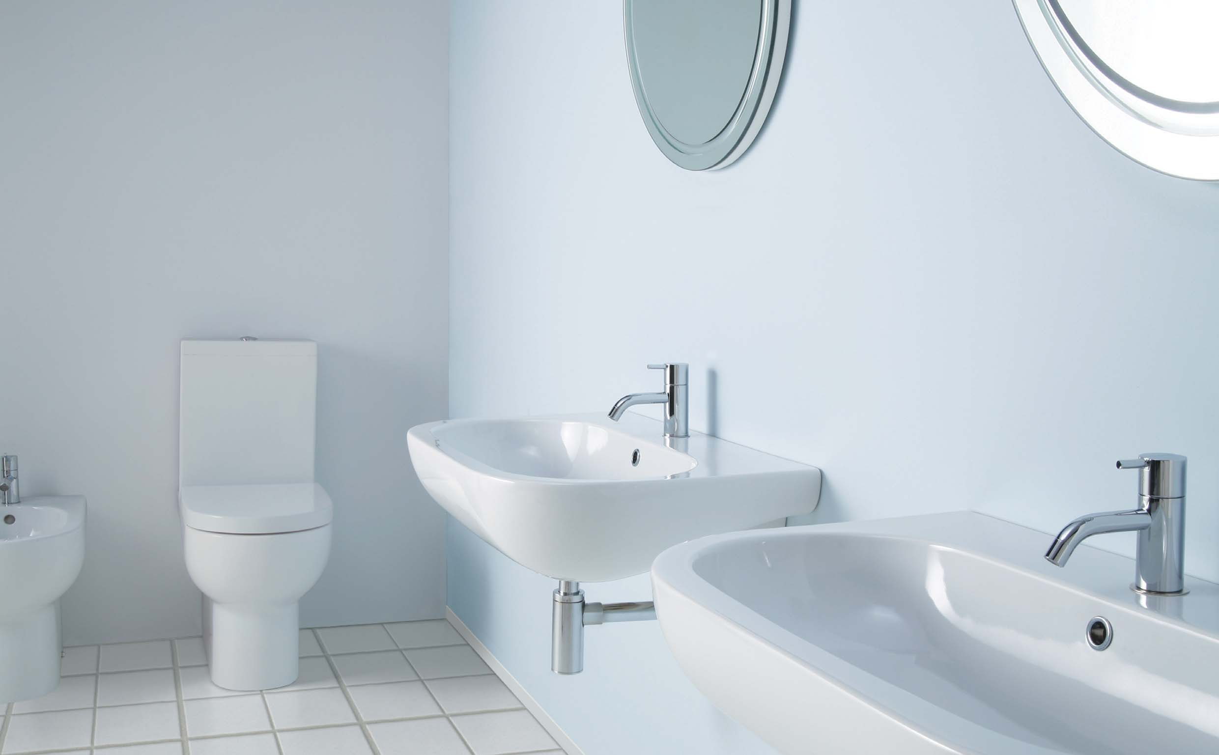 Vaso monoblocco e bidet. Lavabi sospesi cm 60x45, Specchi Tondi cm 60 con molatura interna.