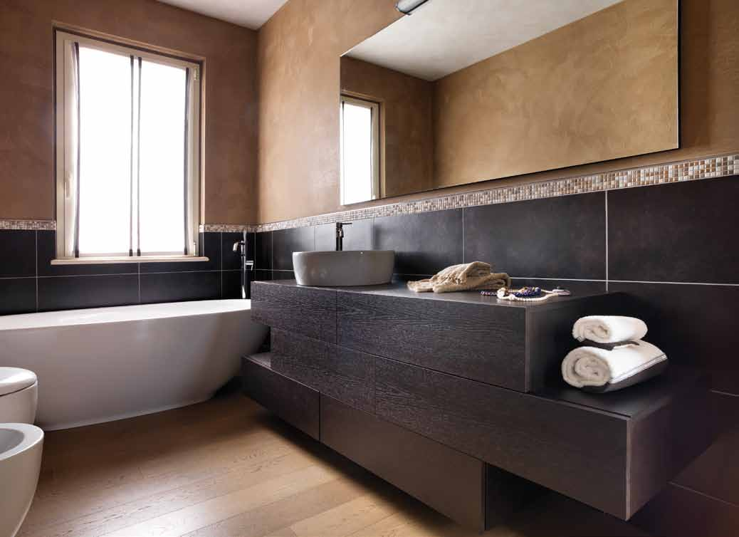 una nuova veste glamour Il bagno padronale moderno e minimalista: il lavandino poggia su un mobile contenitore in wengé, abbinato al rivestimento marrone,