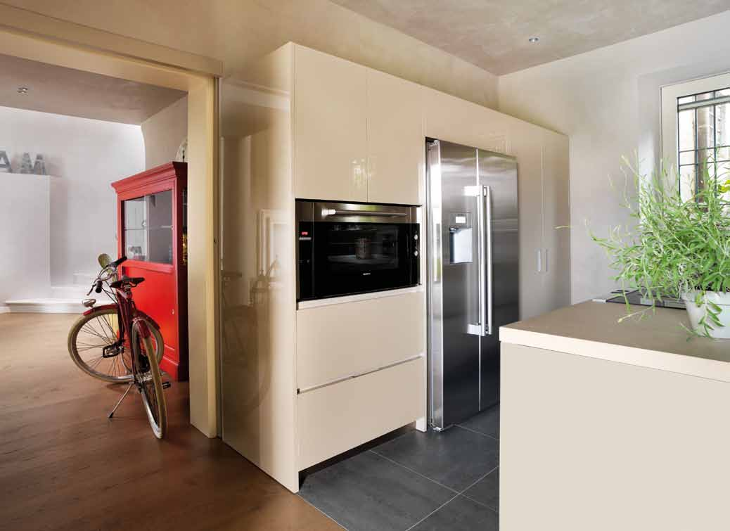 una nuova veste glamour Sopra: scorcio della cucina, compresa nello spazio definito dal pavimento: la composizione moderna, realizzata su misura, è formata da elementi laccati lucidi, color corda