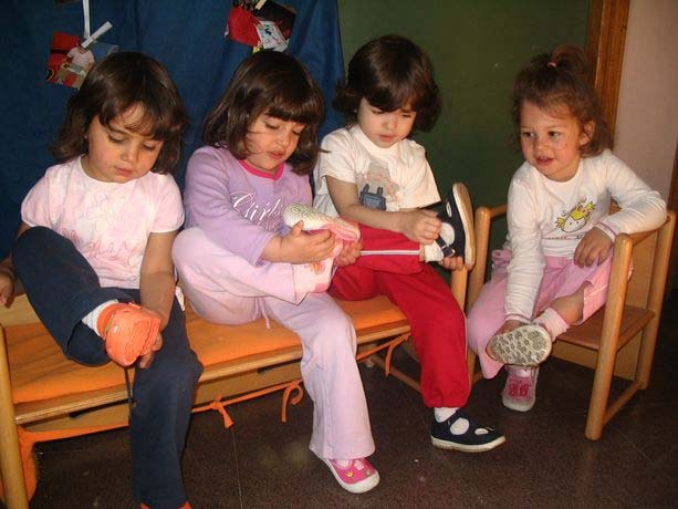 invoglia i bambini e gli adulti a leggere Prima di entrare nella stanza i bambini, seduti su una panca, si tolgono le