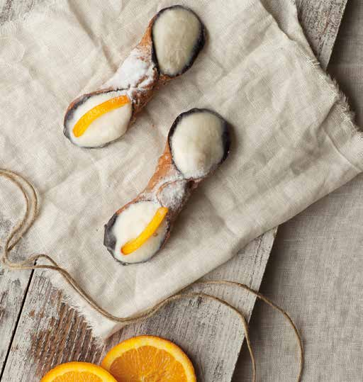 Cialda ripiena di crema di ricotta con gocce di cioccolato e decorato con un filetto di arancio e una spolverata di zucchero a velo.