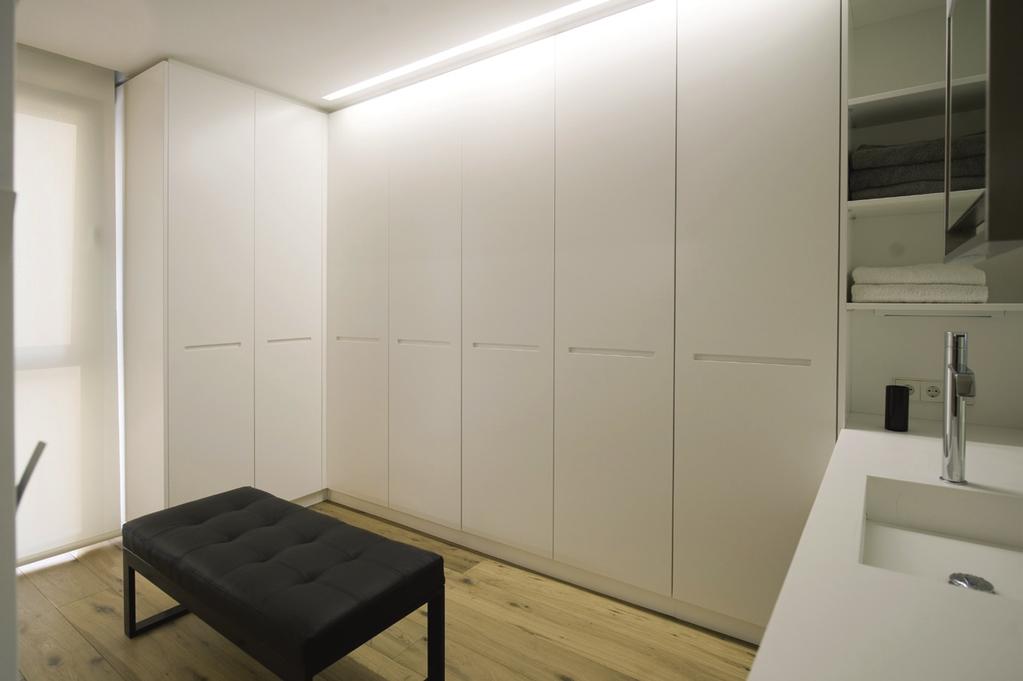 Un taglio di luce a led nel controsoffitto garantisce la giusta illuminazione anche con le ante dell armadio aperte.