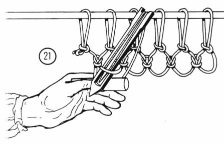 Fig. 21 Seconda operazione: si fa passare l ago, dall alto in basso, nella maglia tenendo il