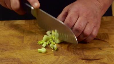 2 Tritate finemente la carota dopo aver raschiato la parte più esterna e aggiungetela al pentolino insieme al sedano. Procedete allo stesso modo anche con la cipolla.