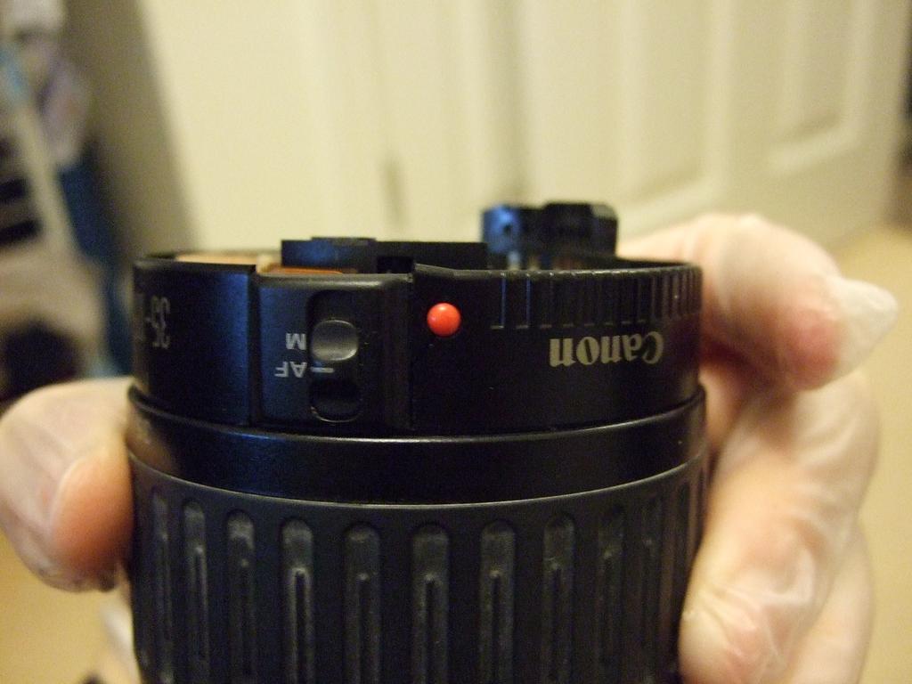 Passo 3 Rimuovere il coperchio posteriore, e quindi rimuovere la guarnizione in gomma (mostrata in luogo intorno al bordo della lente in questa foto).