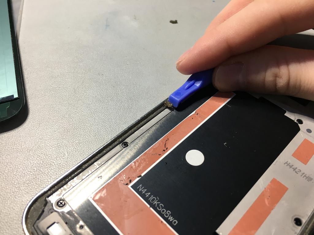 Sostituzione Samsung Galaxy S5 lettore di impronte digitali Passo 19 Rimuovere l'adesivo rimanente Raschiare l'adesivo residuo dai bordi del midframe utilizzando un attrezzo della leva di plastica.