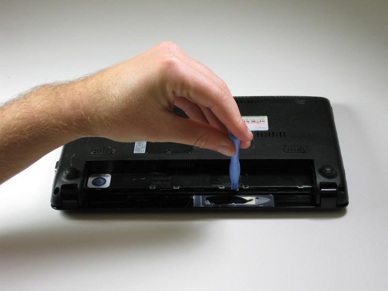 Passo 3 Tastiera Utilizzare uno strumento di apertura in plastica per tirare fuori i quattro fermi di metallo nella cavità della batteria.
