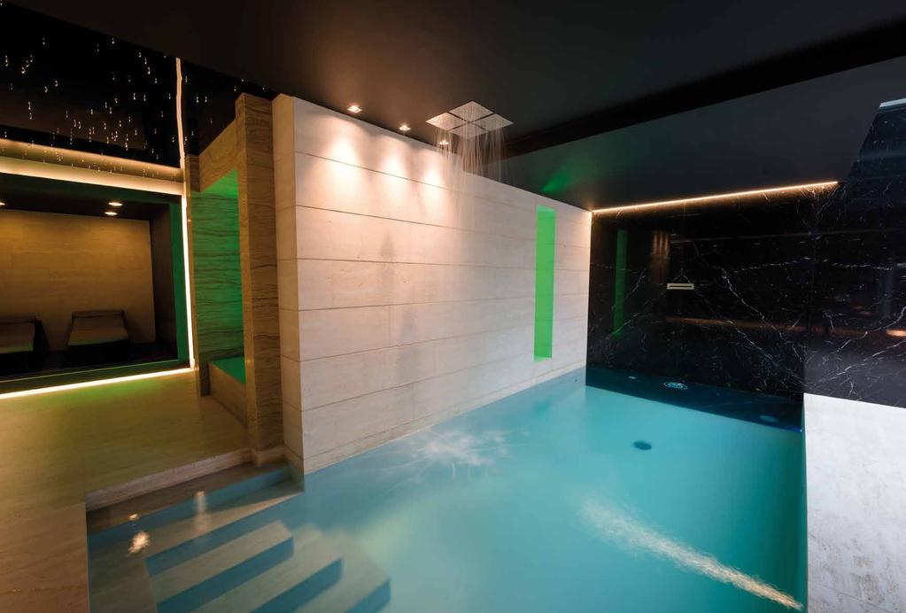 La piscina è illuminata da due fari a LED RGB, che accentuano ancor più l azzurro cielo assegnato alla vasca, e creano un emozionante contrasto con la parete in marmo nero Maquinia lucido, che