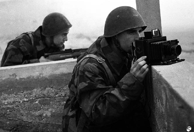 A COLPI DI FLASH Spesso i fotografi si rappresentavano accanto a fucili e mitragliatrici, paragonando la propria macchina fotografica a un arma. Fotografo Luce, 1944.