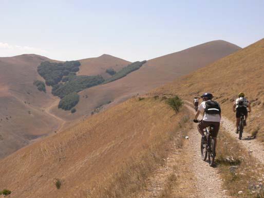 segnavia bianco rossi, che prosegue ora in discesa fino ad un tratto dove si apre di nuovo sotto noi la piana e, percorrendo un tratto ripido, arriviamo ad una vasca adibita ad abbeveratoio per il