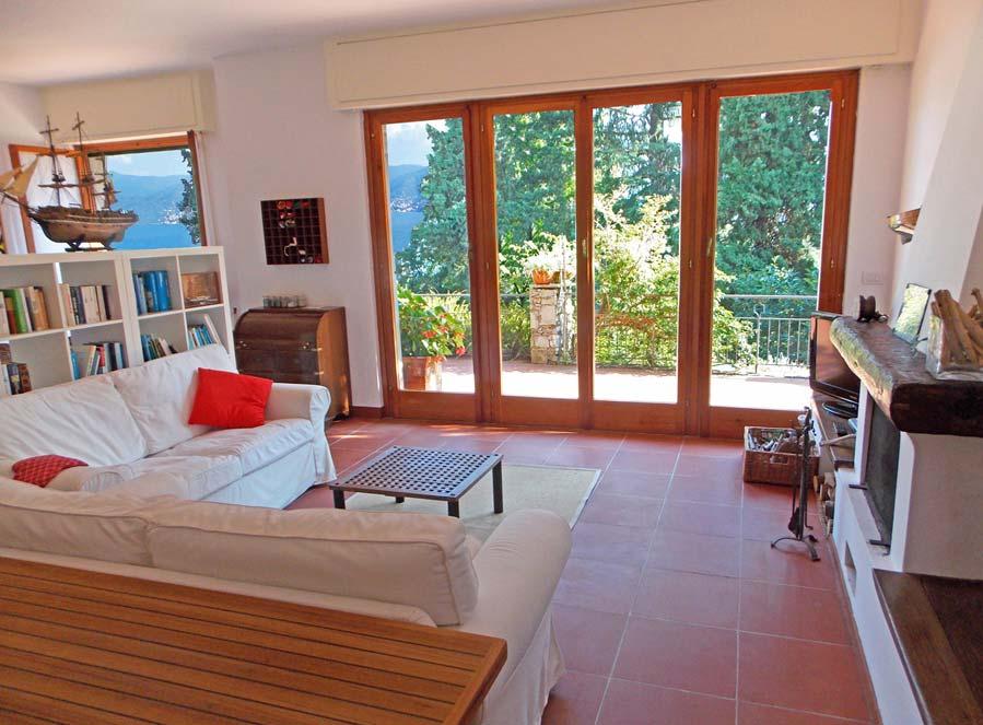 Il soggiorno comprende una parte living con divani e poltrone che con le finestre aperte sono un tutt