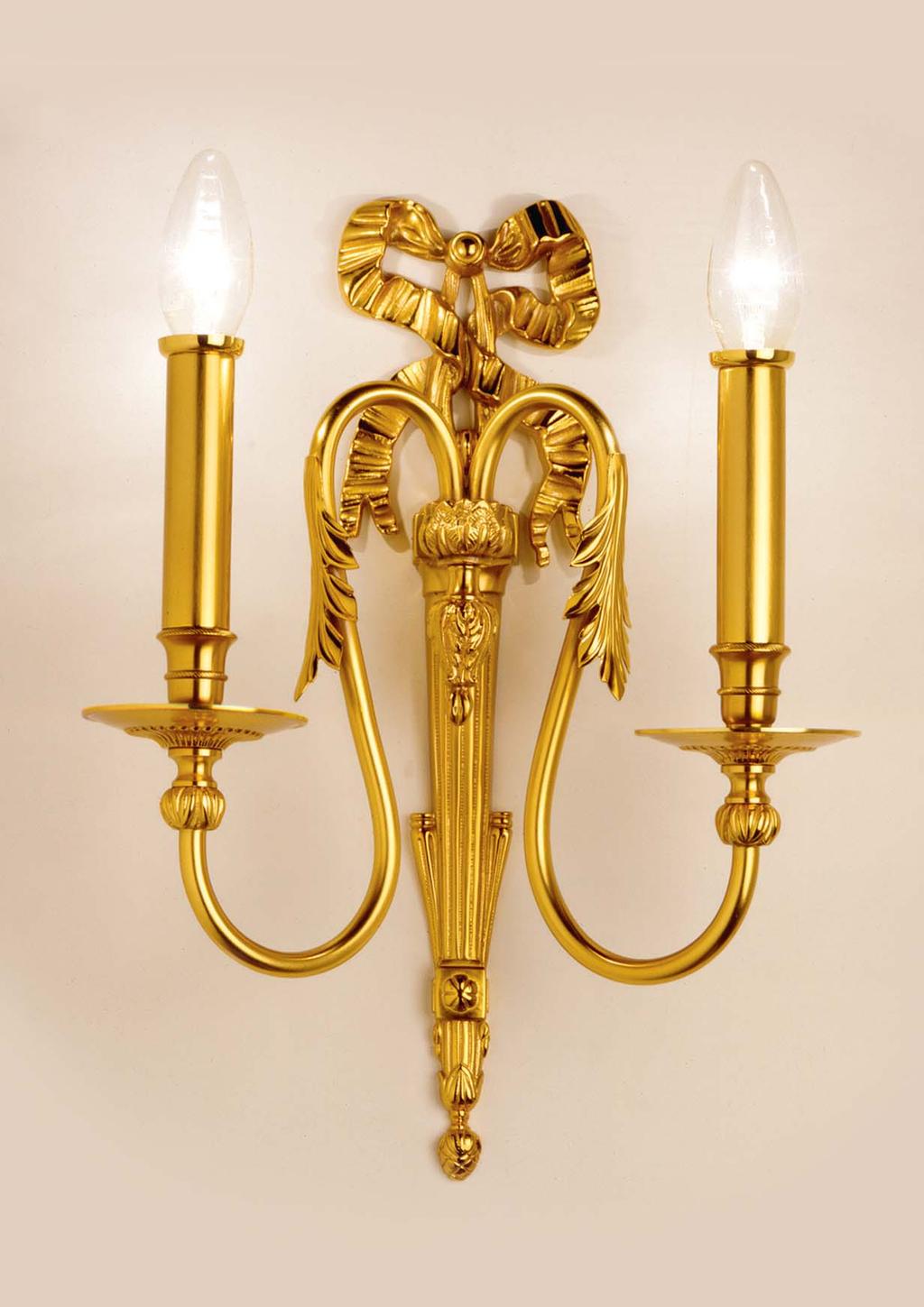 Wall lamp made of patinated fine gold-plated brass with hand-chiselled cast details. It can be provided with one halogen bulb. h. (height) cm.