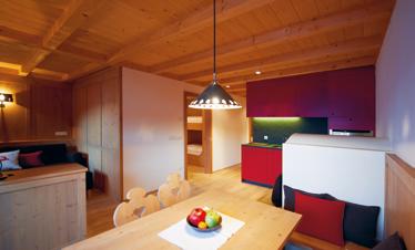 Residence 4-5 PERSONE 70 m 2 Helmut SUPERIOR Ampio soggiorno con comodo divano letto, angolo cucina e angolo pranzo in stile tirolese, stufa contadina con panca.