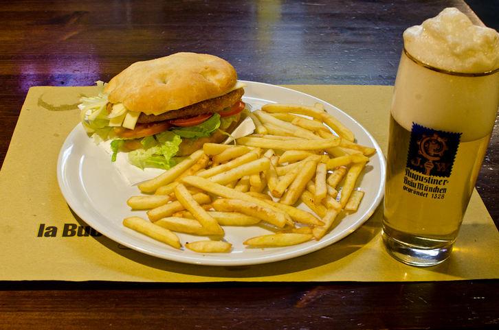 manzo con pomodoro, cipolla, insalata, peperoni, cipolla grigliata, bacon, cheddar, salse e patatine fritte.