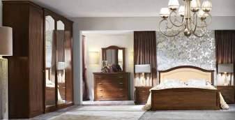 Room in noce verniciato, bed Cleope with headboard embellished with decoration in wrought iron. Wardrobe with four hinged doors with mirrors on central unit.