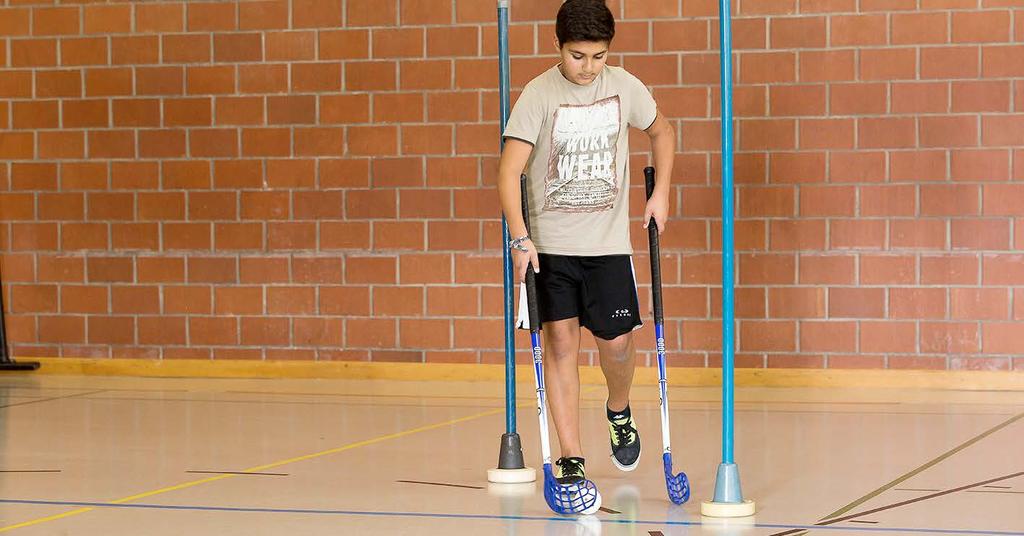 Doppio bastone Ogni bambino ha due bastoni da unihockey. Tiene un bastone con la mano destra e uno con la sinistra.