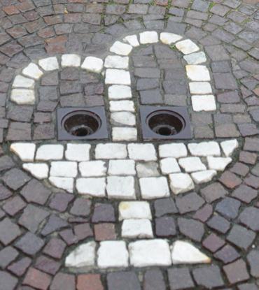 Domanda 16: Sempre in Via Saracco, abbassate gli occhi: ecco un simbolo bianco messo a terra, al centro della via. Secondo voi cosa rappresenta?