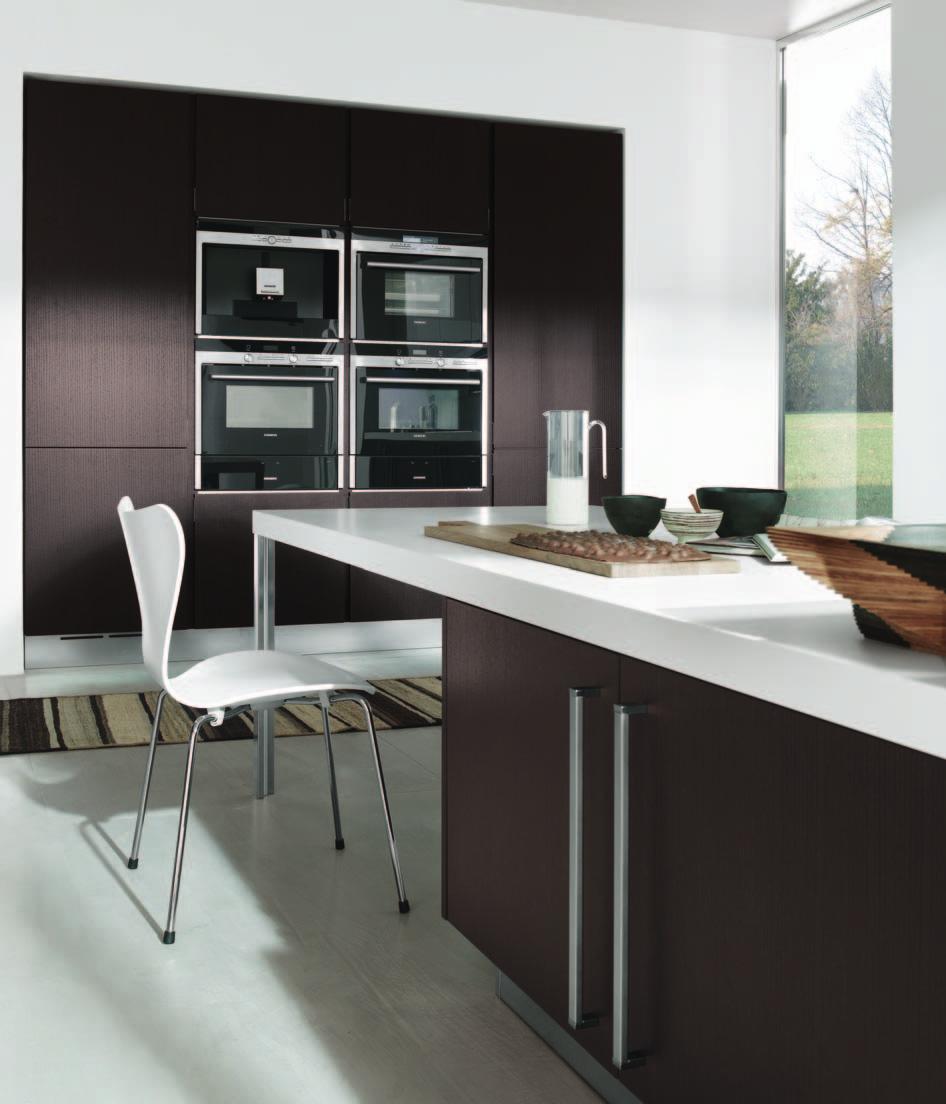 Rovere caffè per la cucina e l isola centrale con piano di lavoro Monos, realizzato in laminato bianco unicolor e blocco cottura in acciaio inox.