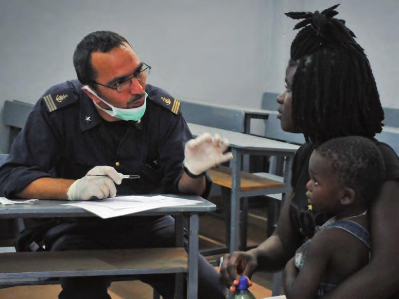 Il Capo di 1^ classe infermiere Tommaso Giandomenico durante un colloquio anamnestico con una mamma africana e il suo bambino. (foto Corrado Carrubba) Nave Etna.