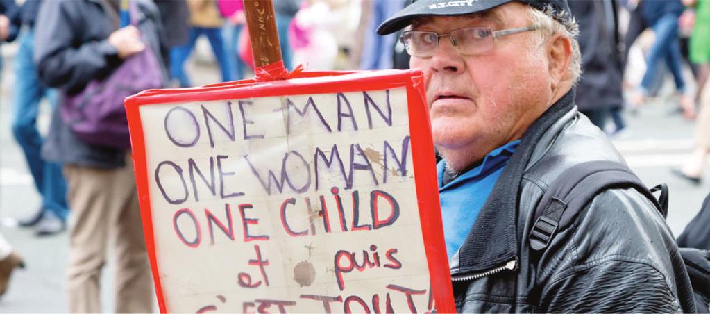 Parigi, Francia, 5 ottobre 2014: Durante una manifestazione a Parigi contro i diritti gay un uomo tiene un cartello con la scritta: Un uomo, una donna, un bambino e questo è tutto!