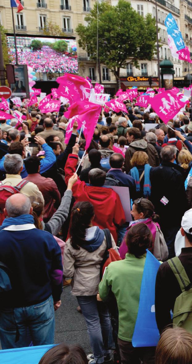 Parigi, Francia, 5 ottobre 2014: manifestanti agitano delle bandiere rosa durante una manifestazione contro i diritti LGBT che ha visto circa 100.000 partecipanti. 8.