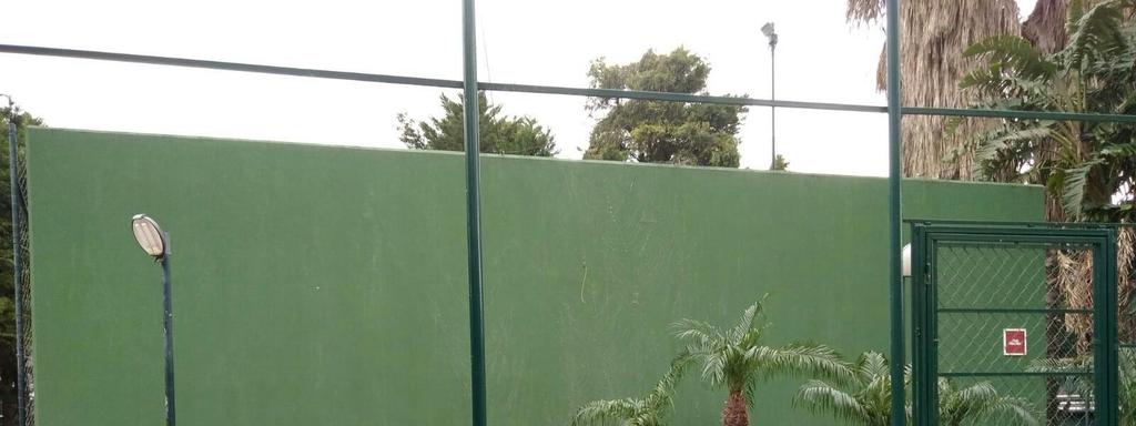 prospetto B: si trova nella area campus per bambini, sul viale che porta ai campi da tennis in mantoflex e la palestra. La superficie è un muro in cemento armato di colore verde, liscio.