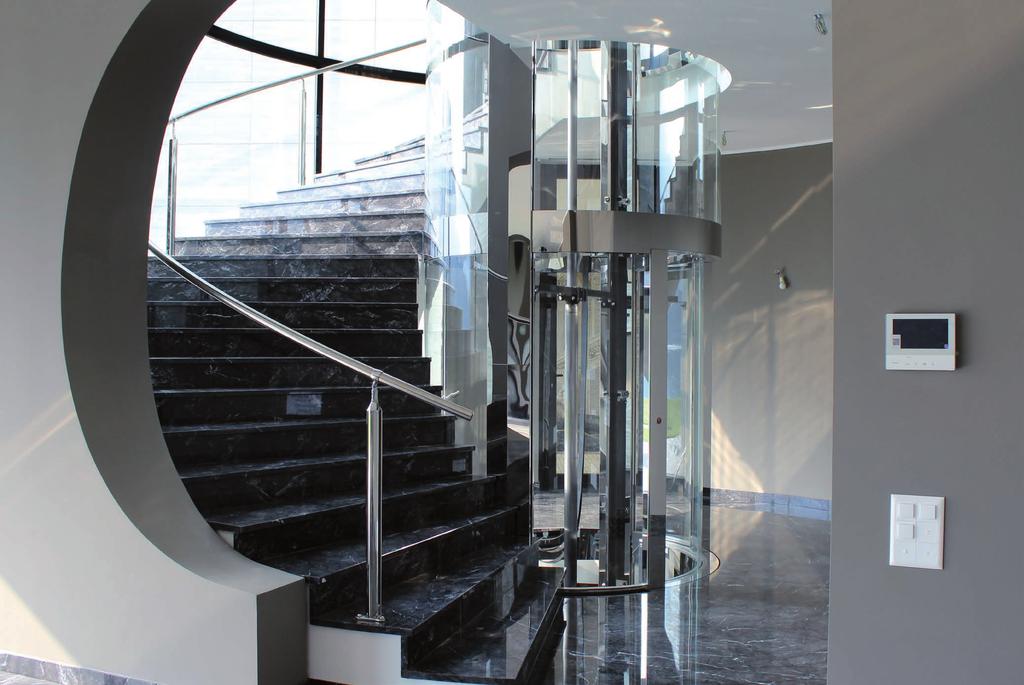 In una villa con finiture extra lusso, l ascensore circolare in acciaio inox lucido si inserisce in una scala in marmo nero.