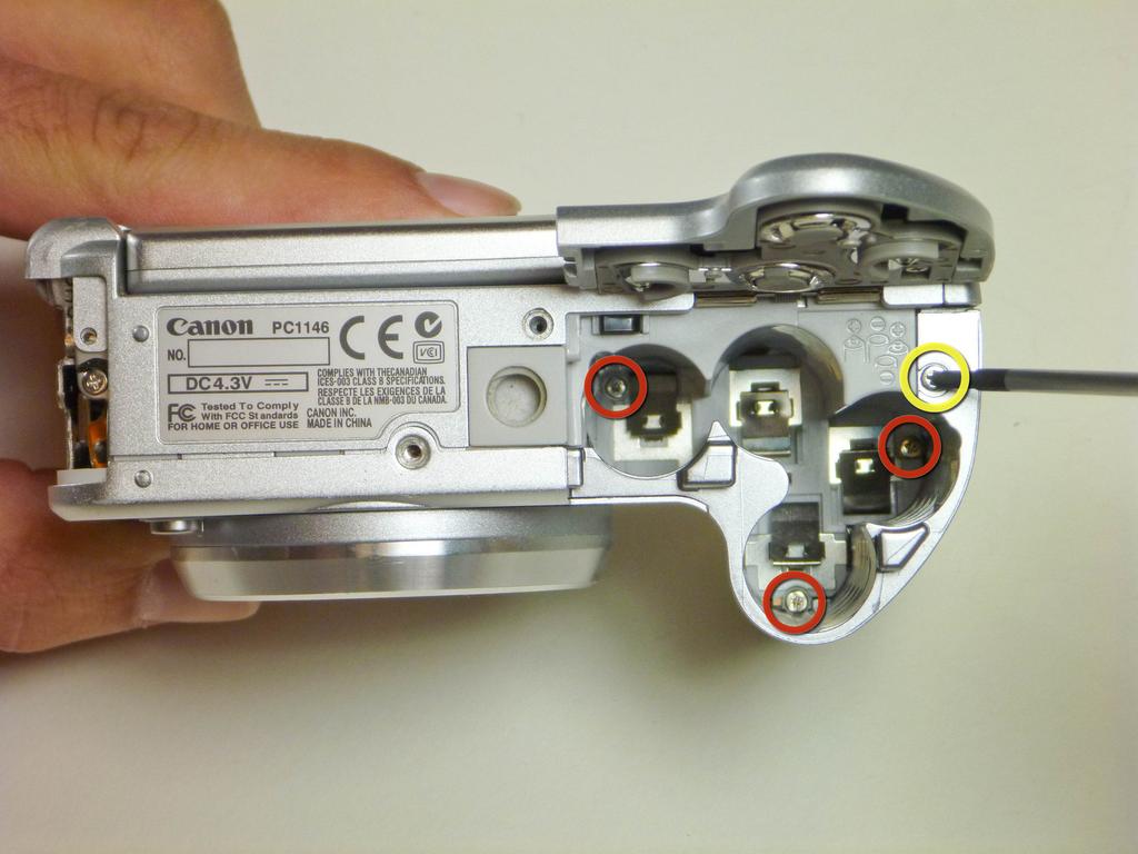 Passo 5 Aprire il coperchio della batteria. Rimuovere la vite 5 mm, si trova sulla parte superiore del vano batterie.