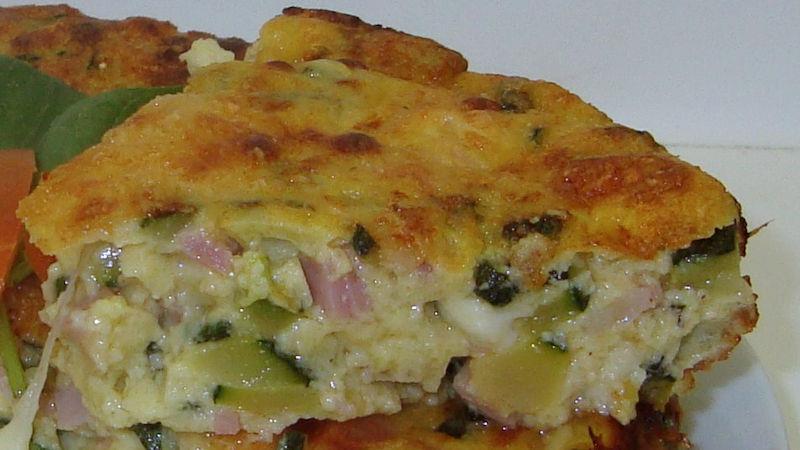 Tortino zucchine e speck Quantità: Stampo da 24 cm 600 g zucchine 100 g speck 1 scalogno 300 g farina 0 30 g olio extravergine di oliva 50 g parmigiano reggiano 3 uova 125 g ricotta 1 bustina lievito