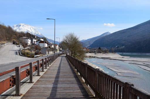 dalla presenza di panchine in calcestruzzo. Sulla sinistra il percorso sulla sponda del lago è protetto da cordolo in calcestruzzo su cui si poggia un parapetto in legno e acciaio.