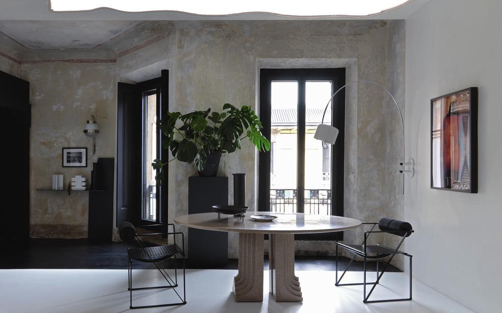 Il tavolo in granito, design Carlo Scarpa per Simon, è originale del 1970. Sul piano, alzata e vaso di Paola C. e piatto Fornasetti. Sedie Seconda di Mario Botta per Alias.