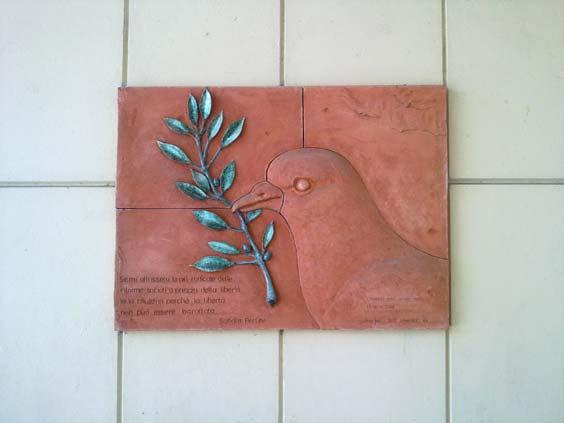 Ai Principi della Libertà La lapide consta di un bassorilievo raffigurante il profilo di una colomba che stringe nel becco un ramoscello di ulivo.