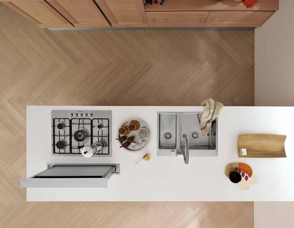 The kitchen is characterised by the combination of two different types of wood: white open pore oak and old oak. It is built on two parallel lines, connected by a series of very large wall units.