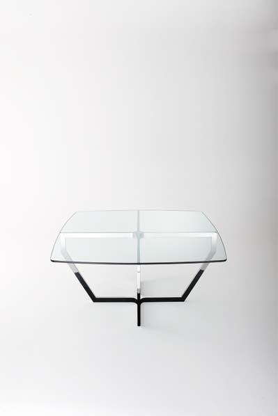 Table avec joint central chromé et dessus en verre transparent de 15mm d épaisseur. Structure en acier inox brillant.