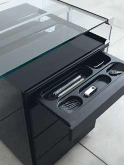 Drawer unit in metal with sides covered with white or black painted glass. On castors. Pull-out drawers. Centralized locking system. Stationery drawer. Available with drawer for hanging files.